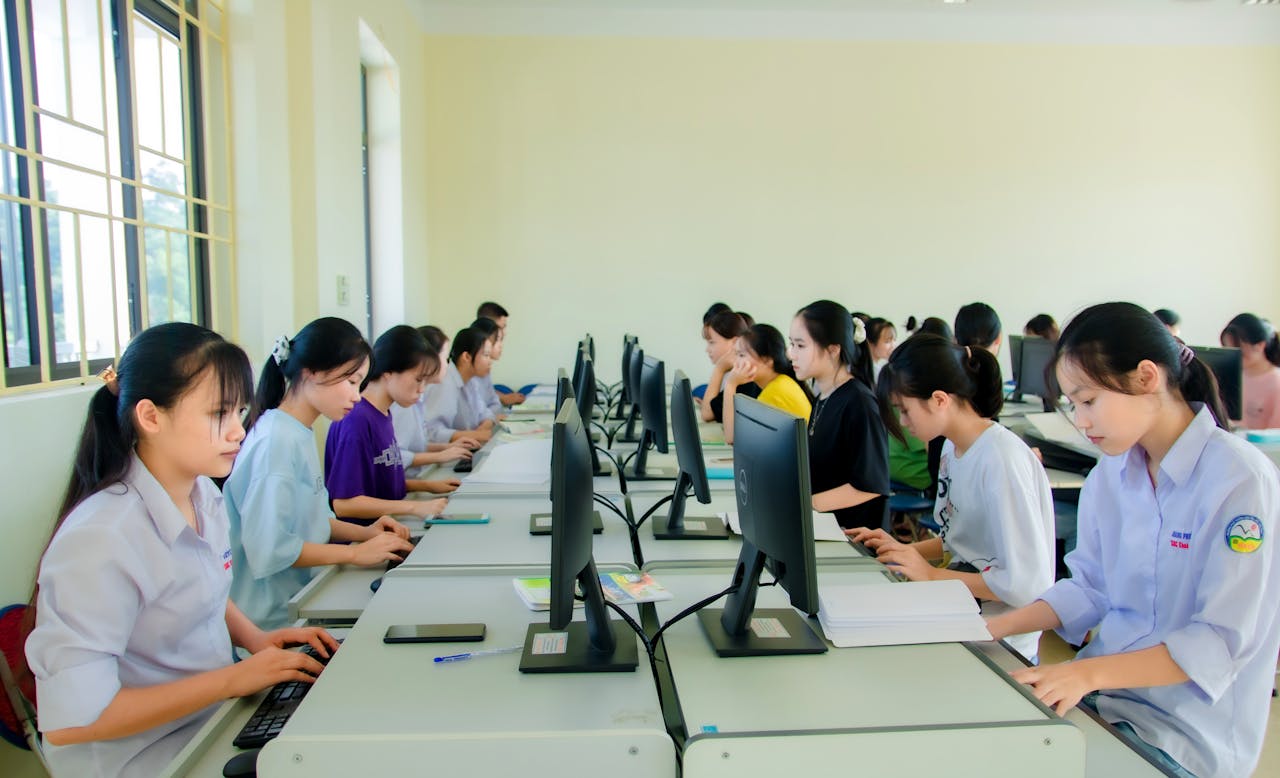 Crafting Captivating Headlines: Your awesome post title goes here A group of students focusing on computers during a class in a university setting, working indoors.